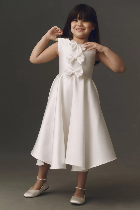 Heowos white flower girl dress with three front bows, a round neckline, sleeveless bodice and tea-length A-line skirt.