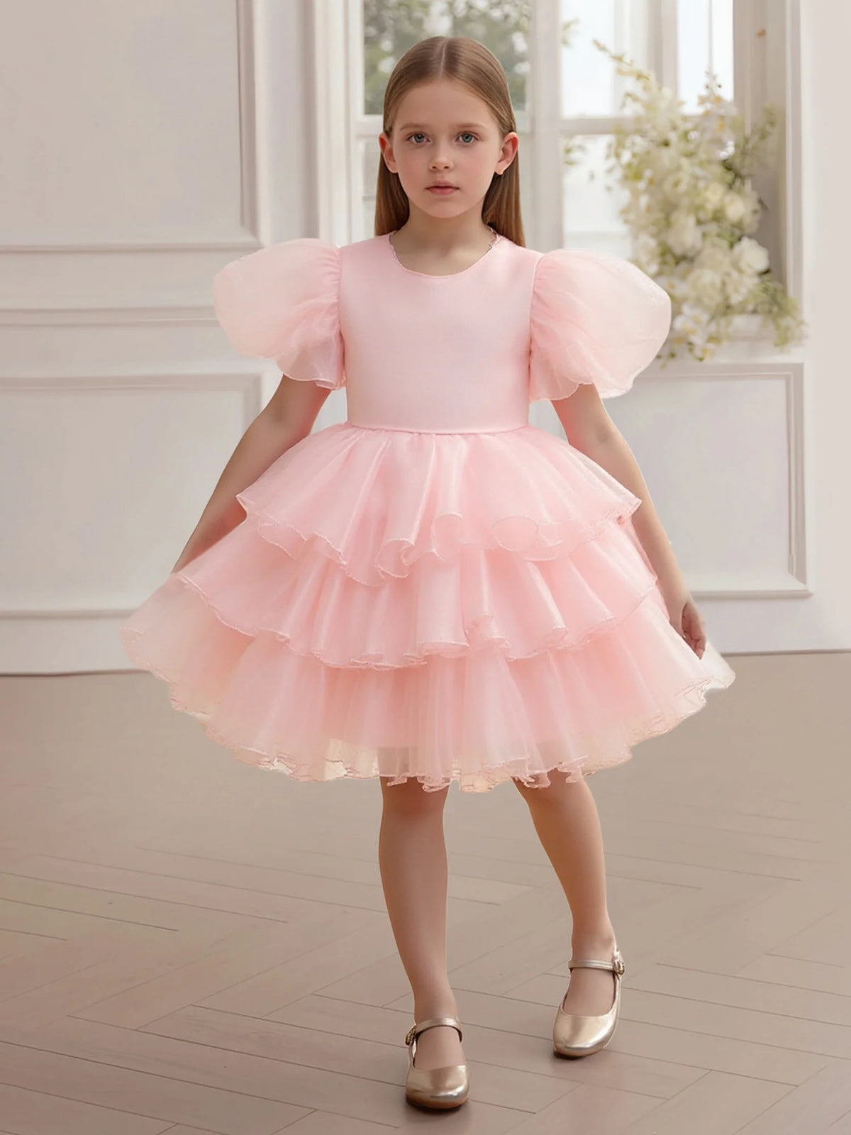 Heowos pink flower girl dress with a round satin bodice, oversized sheer puff sleeves and three cascading ruffle tiers on a knee-length skirt.
